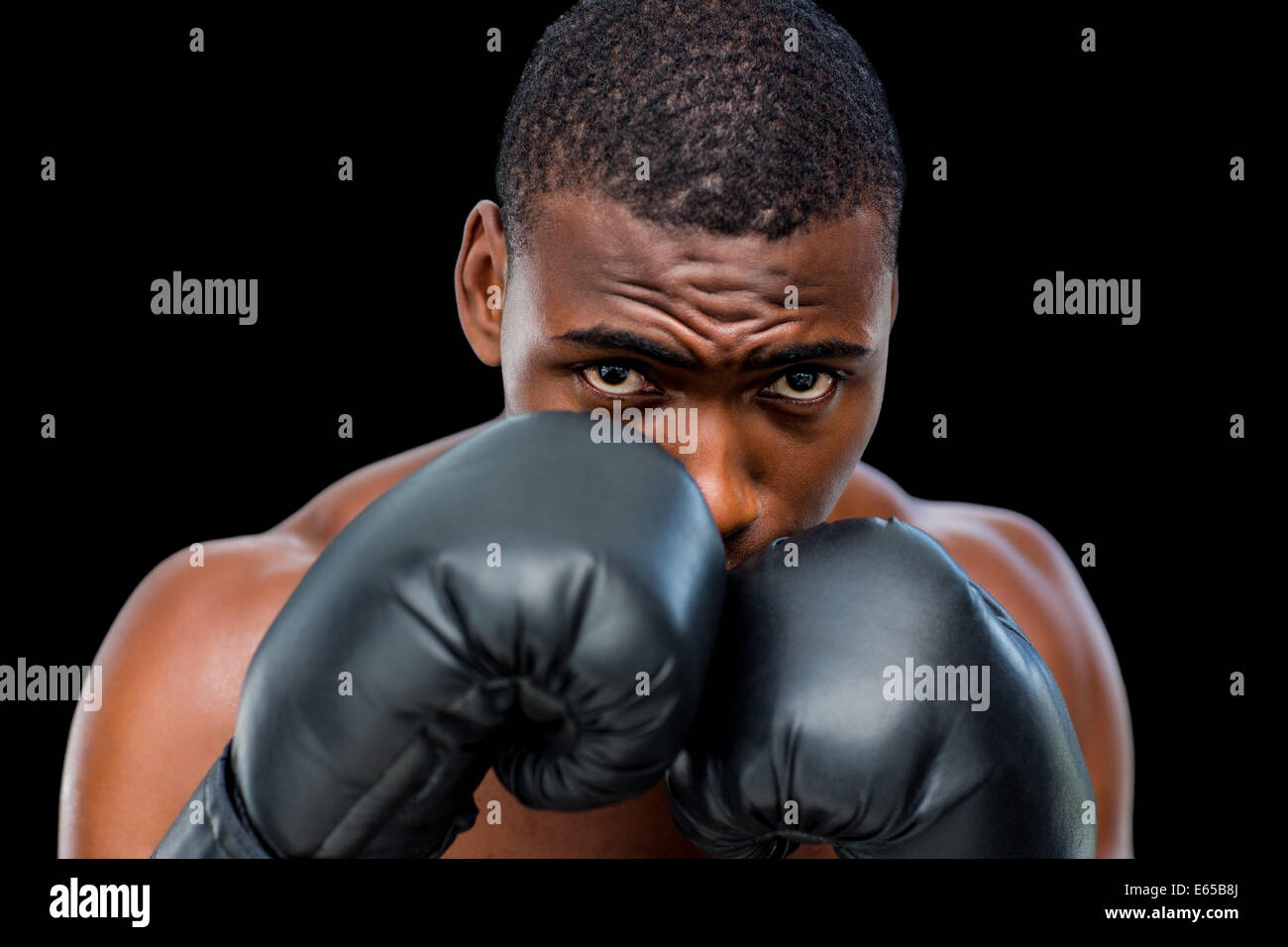 Portrait of a shirtless muscular boxer in defensive stance Stock Photo