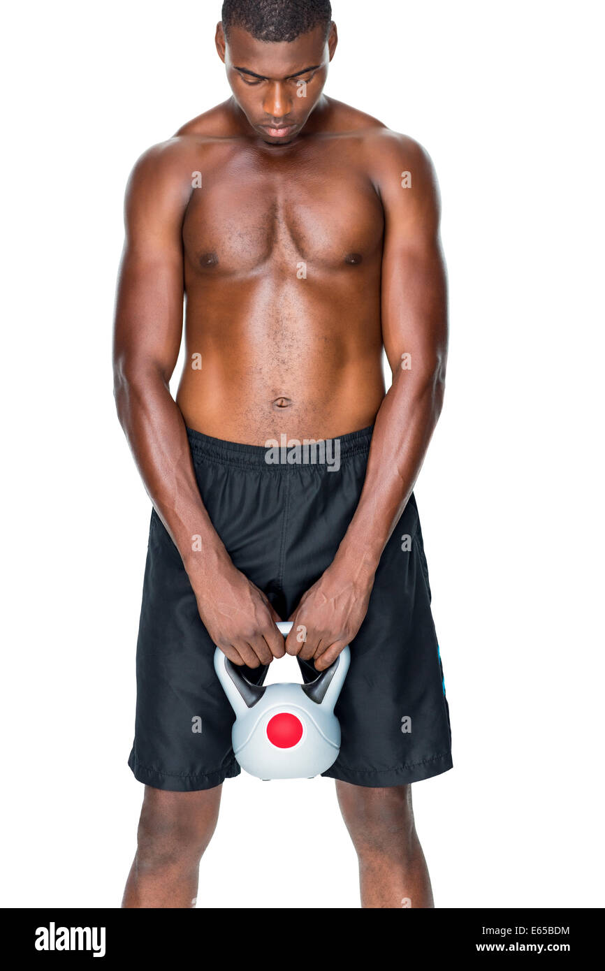Shirtless fit young man lifting kettle bell Stock Photo