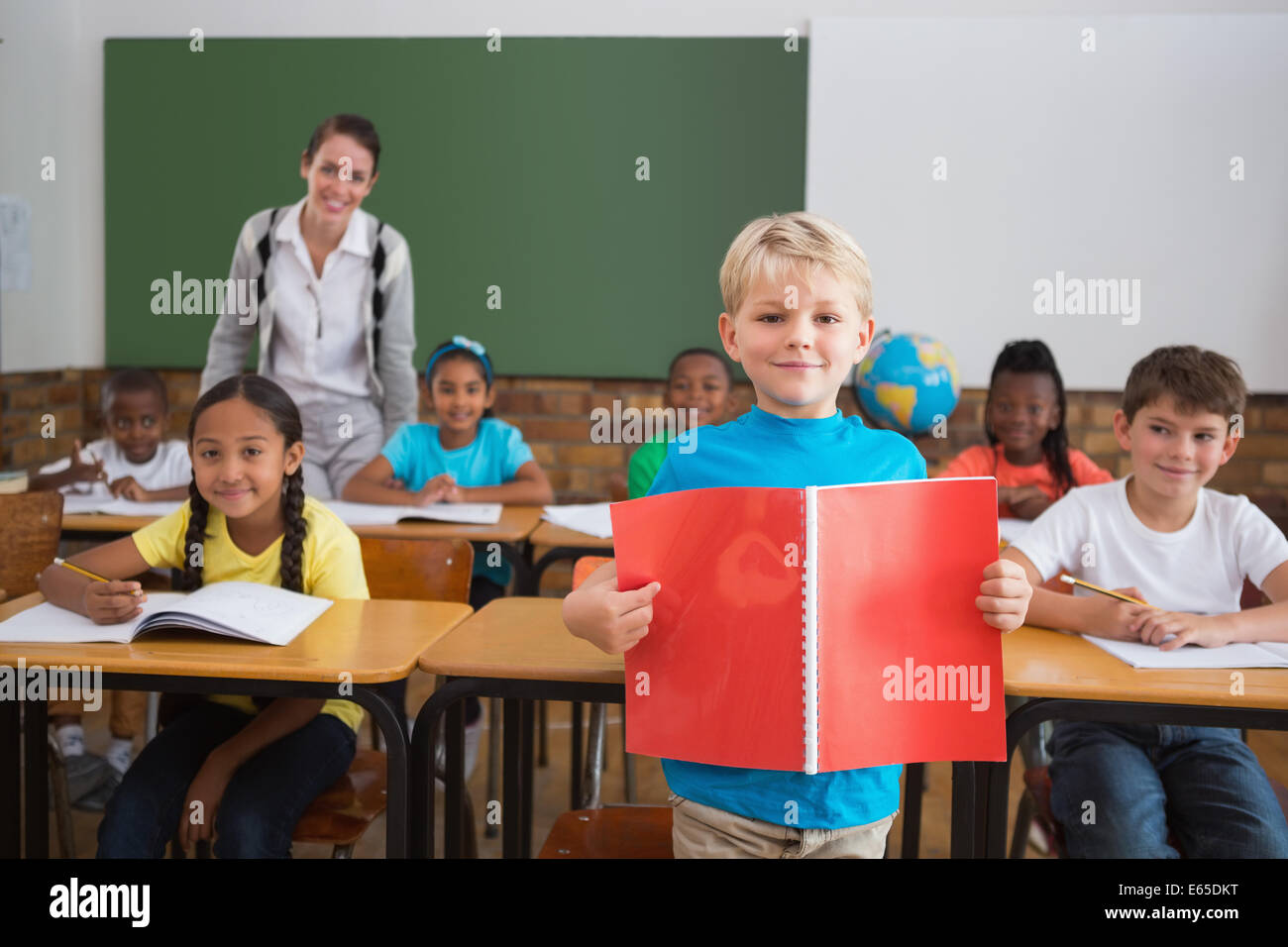 Cute pupils smiling at camera in classroom Stock Photo - Alamy
