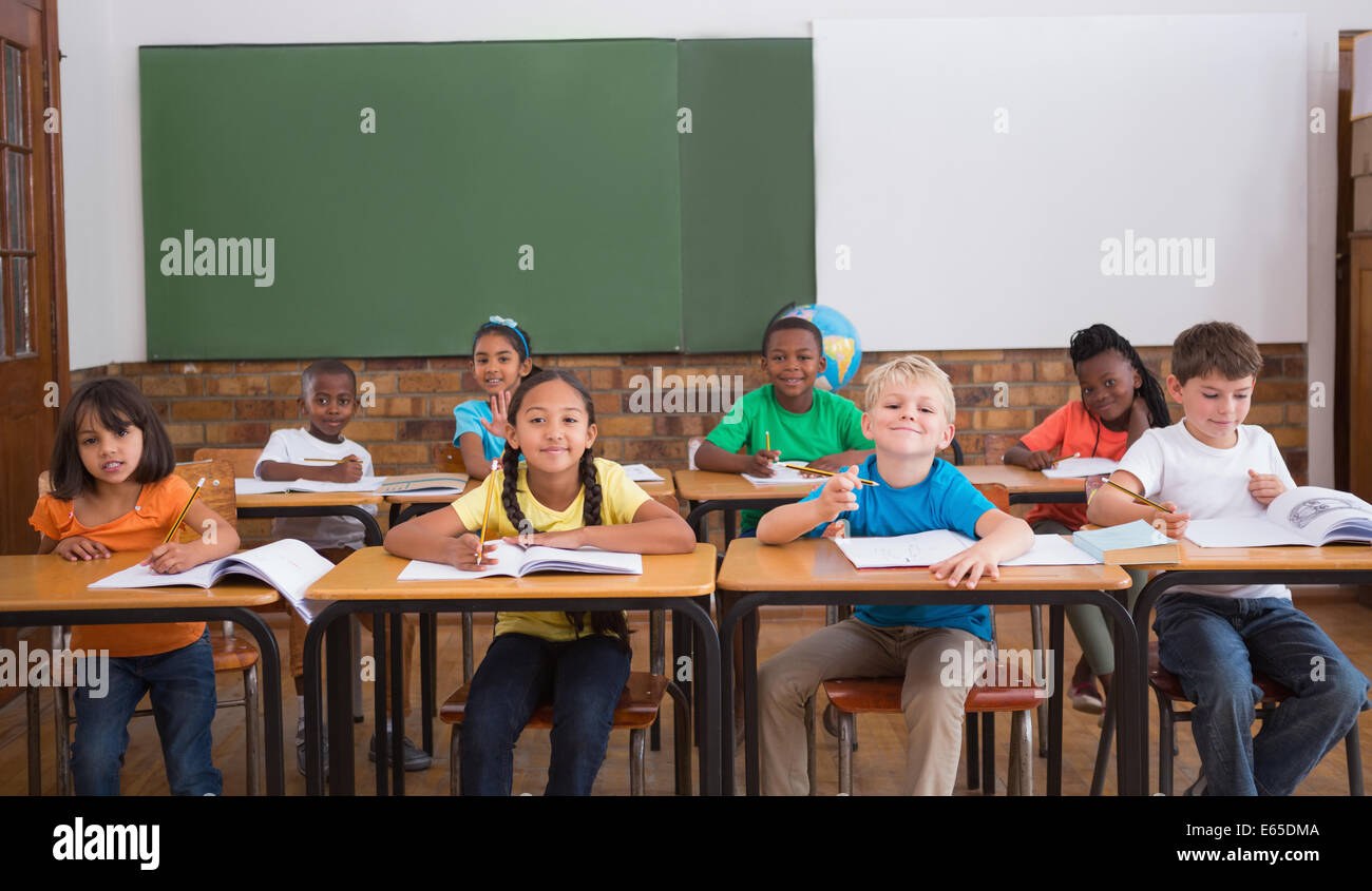 Cute pupils smiling at camera in classroom Stock Photo - Alamy