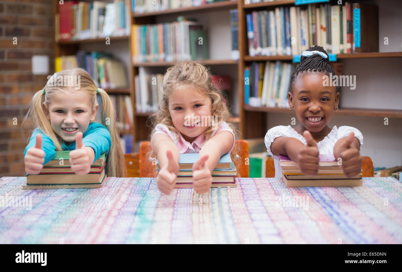 Cute pupils smiling at camera in library Stock Photo - Alamy