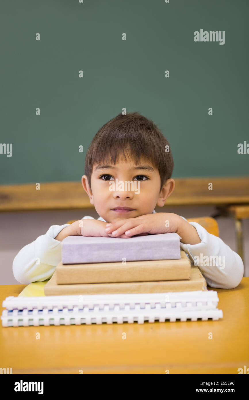 Happy pupil leaning on books at desk Stock Photo - Alamy