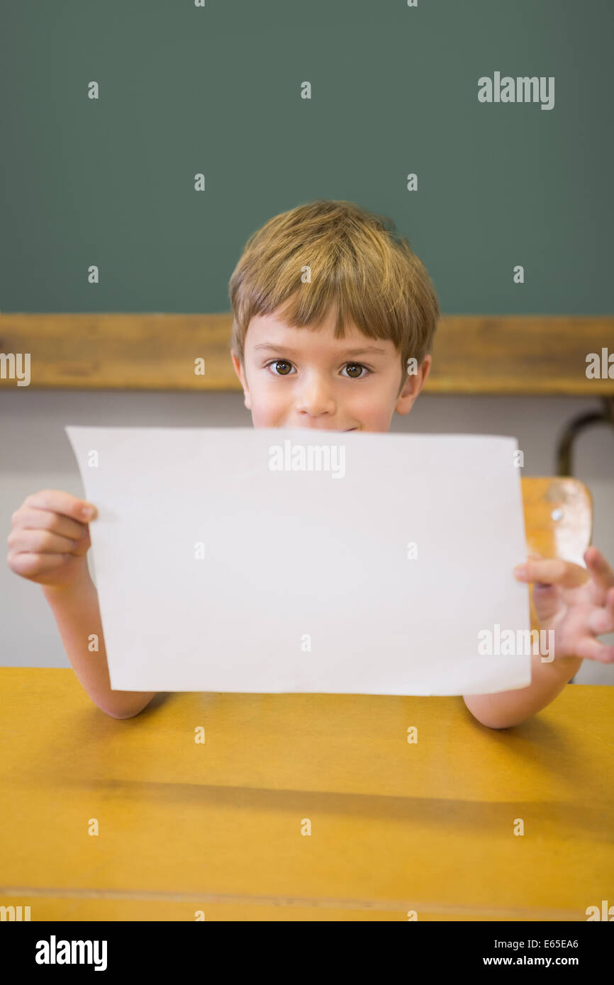 Cute pupil smiling at camera in classroom showing page Stock Photo - Alamy