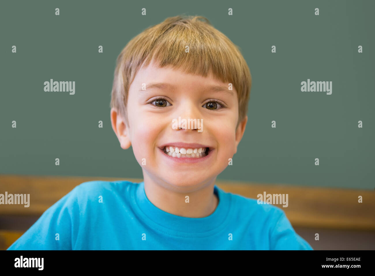 Cute pupil smiling at camera in classroom Stock Photo - Alamy