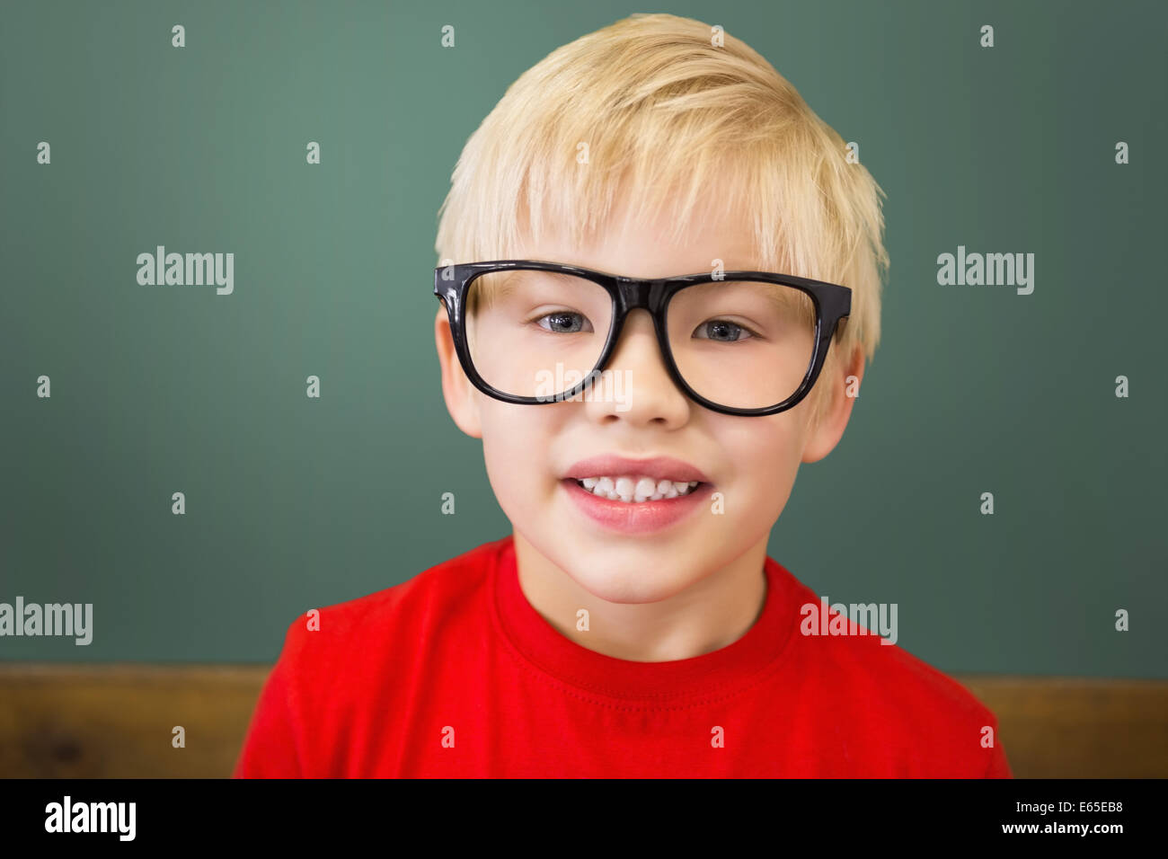 Cute pupil smiling at camera in classroom Stock Photo - Alamy
