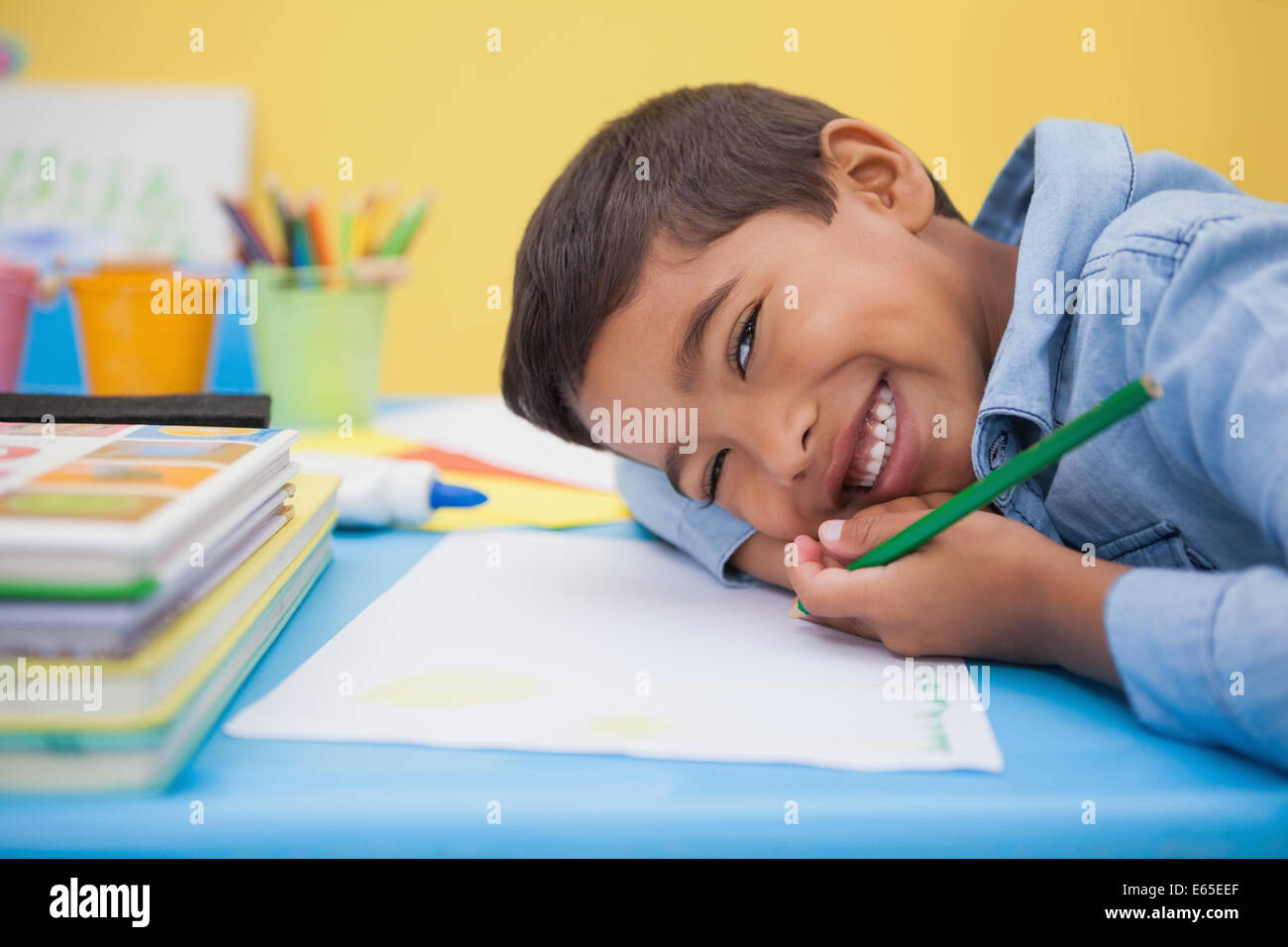 Cute little boy drawing at desk Stock Photo - Alamy
