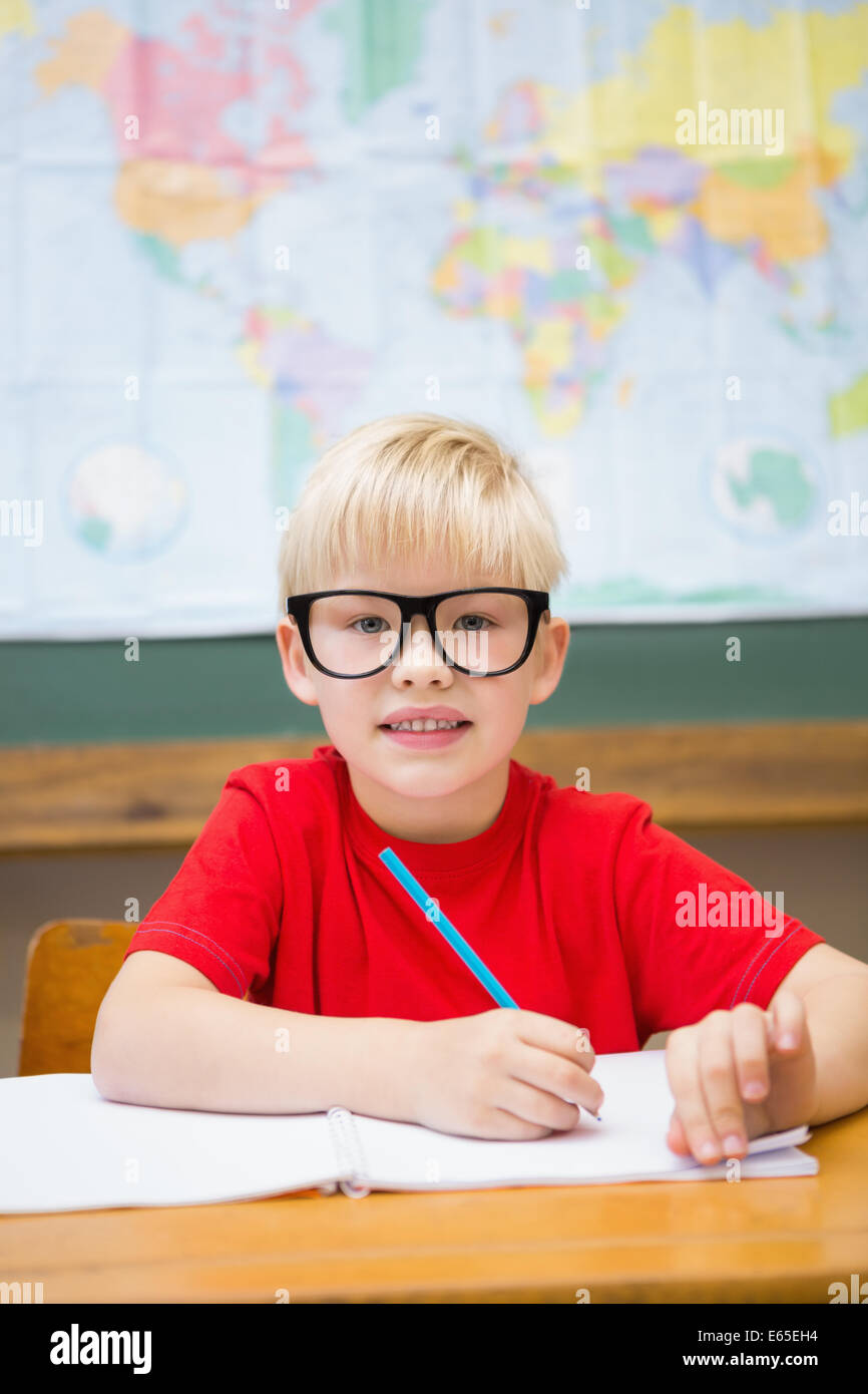 Cute pupil smiling at camera in classroom at his desk Stock Photo - Alamy
