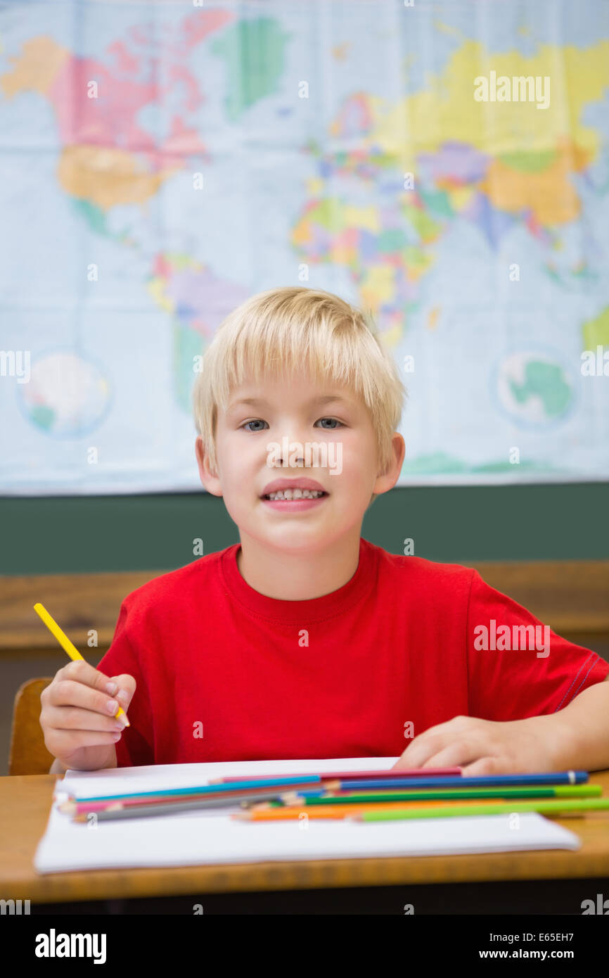 Cute pupil smiling at camera in classroom at his desk Stock Photo - Alamy