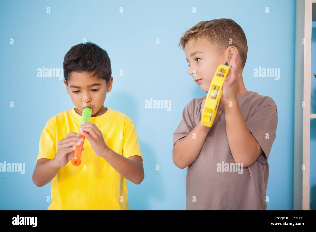 Cute little boys playing musical instruments in classroom Stock Photo