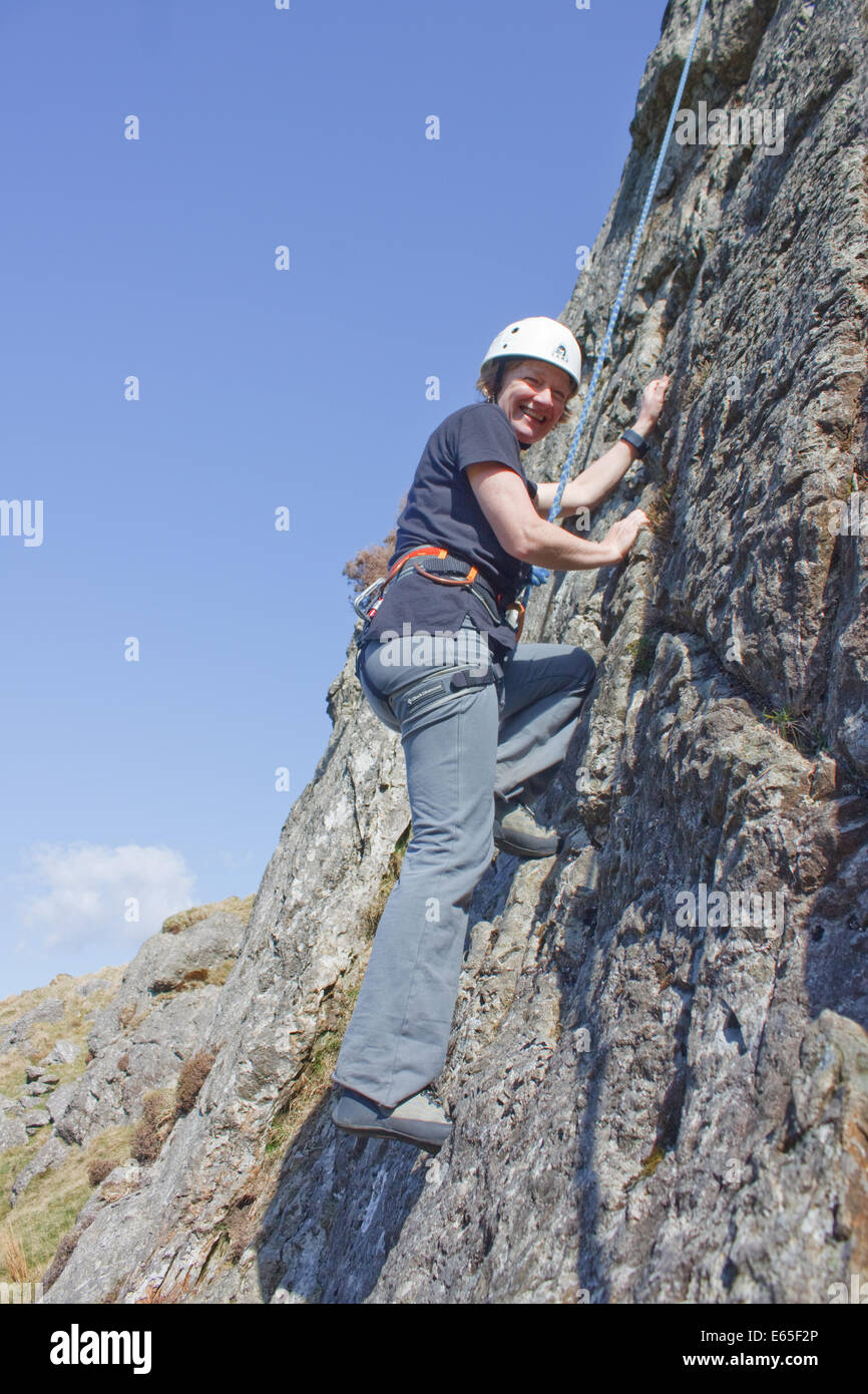 A woman enjoying rock climbing on an outcrop called Col Crag in