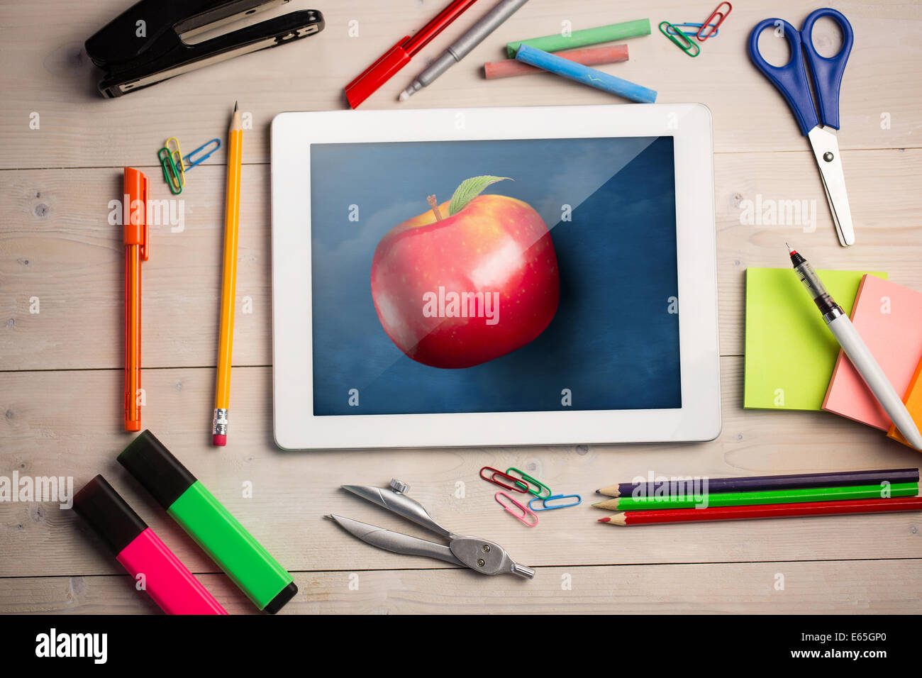 Composite image of digital tablet on students desk Stock Photo