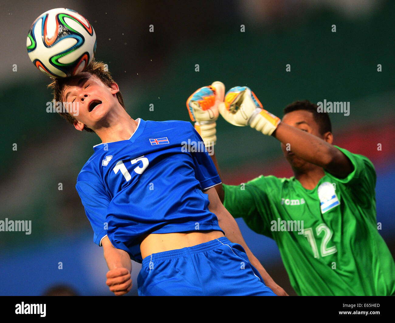 Nanjing, China's Jiangsu Province. 15th Aug, 2014. Gudmundur Andri Tryggvason (L) of Iceland heads the ball during the men's football game against Honduras in group C at Nanjing 2014 Youth Olympic Games in Nanjing, capital of east China's Jiangsu Province, on Aug. 15, 2014. Iceland wins the game 5:0. Credit:  Cheng Min/Xinhua/Alamy Live News Stock Photo