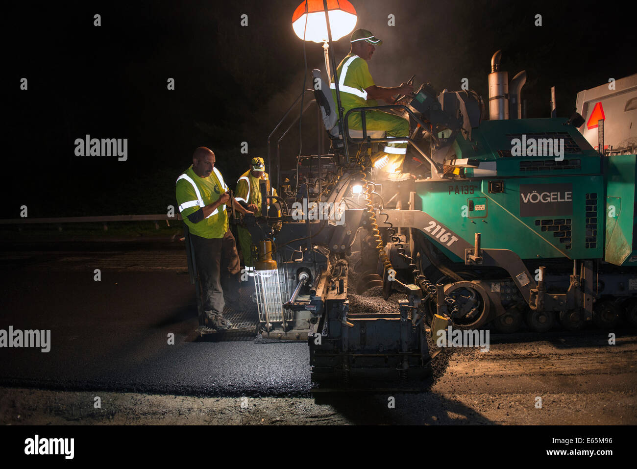 Waters Construction works on nighttime paving on the Merritt Parkway in Connecticut with tracked paving machine made by Vogele Stock Photo