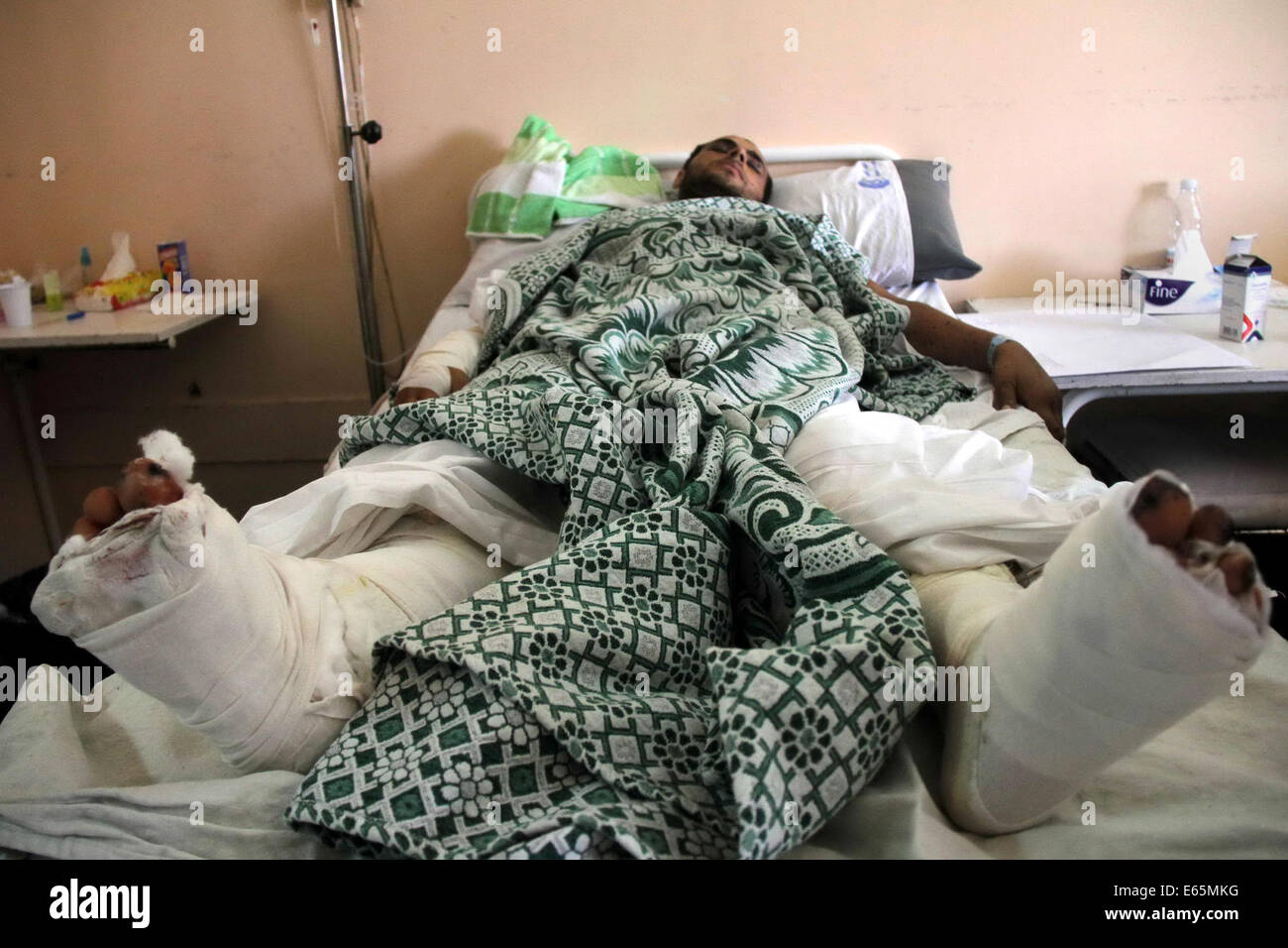 Cairo, Egypt. 15th Aug, 2014. A Palestinian man, who medics said was wounded during the Israeli offensive, lies on a bed at the Red Crescent hospital, Cairo, Egypt on August 15, 2014. Two successive truces since Monday, expected to last through August 19, have largely quieted the guns, after 1,980 Palestinians, most of them civilians, 64 Israeli soldiers and three civilians in Israel were killed Credit:  Mohammed Bendari/APA Images/ZUMA Wire/Alamy Live News Stock Photo