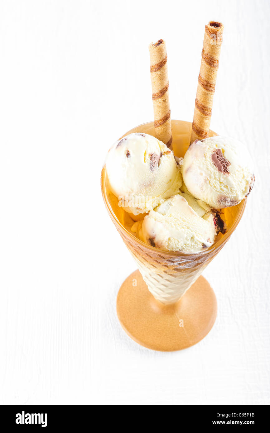 Vanilla ice cream  with wafer in cup on white wooden background Stock Photo