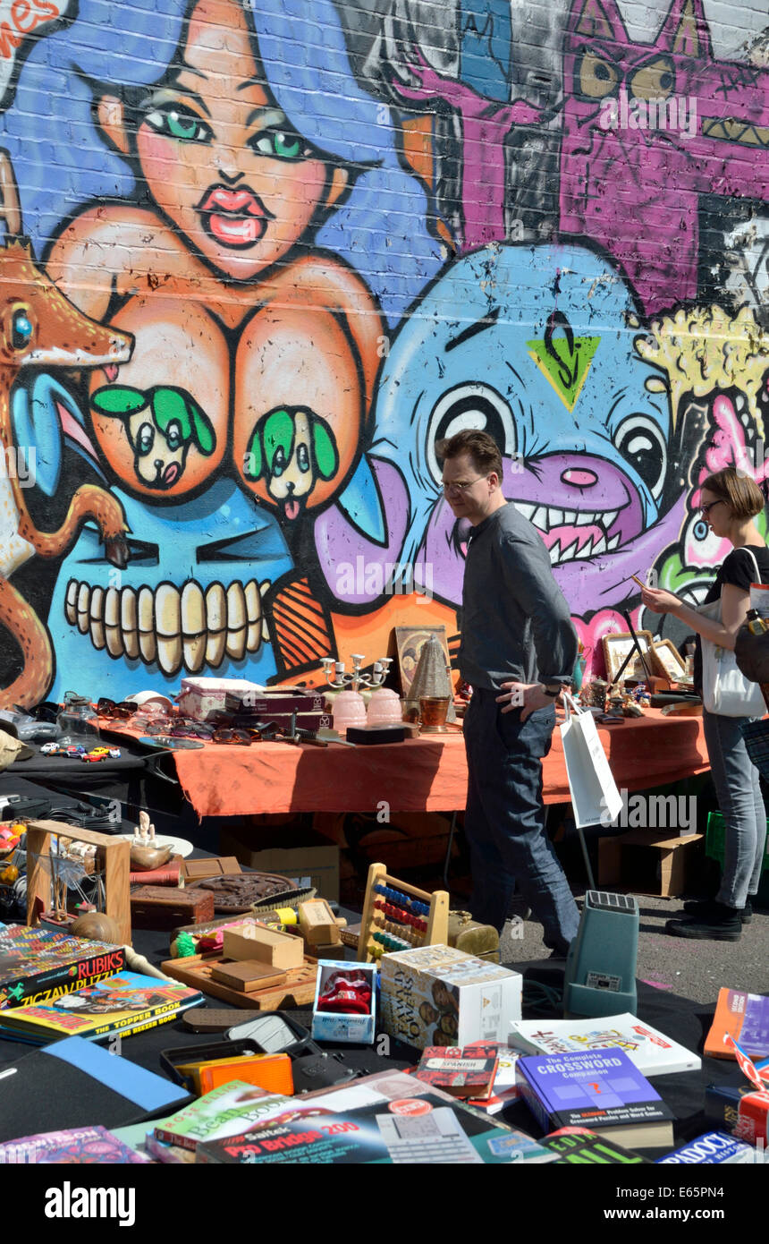 A young couple looking at bric-a-brac on a street market stall near Brick Lane, London, UK Stock Photo