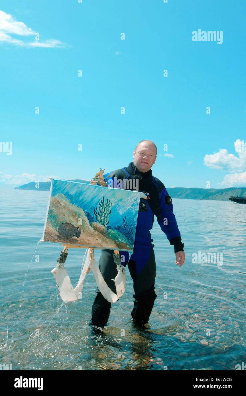 Underwater artist Yuriy Alexeev (Yuri Alekseev) out of the water with the picture painted in the water. Baikal Stock Photo