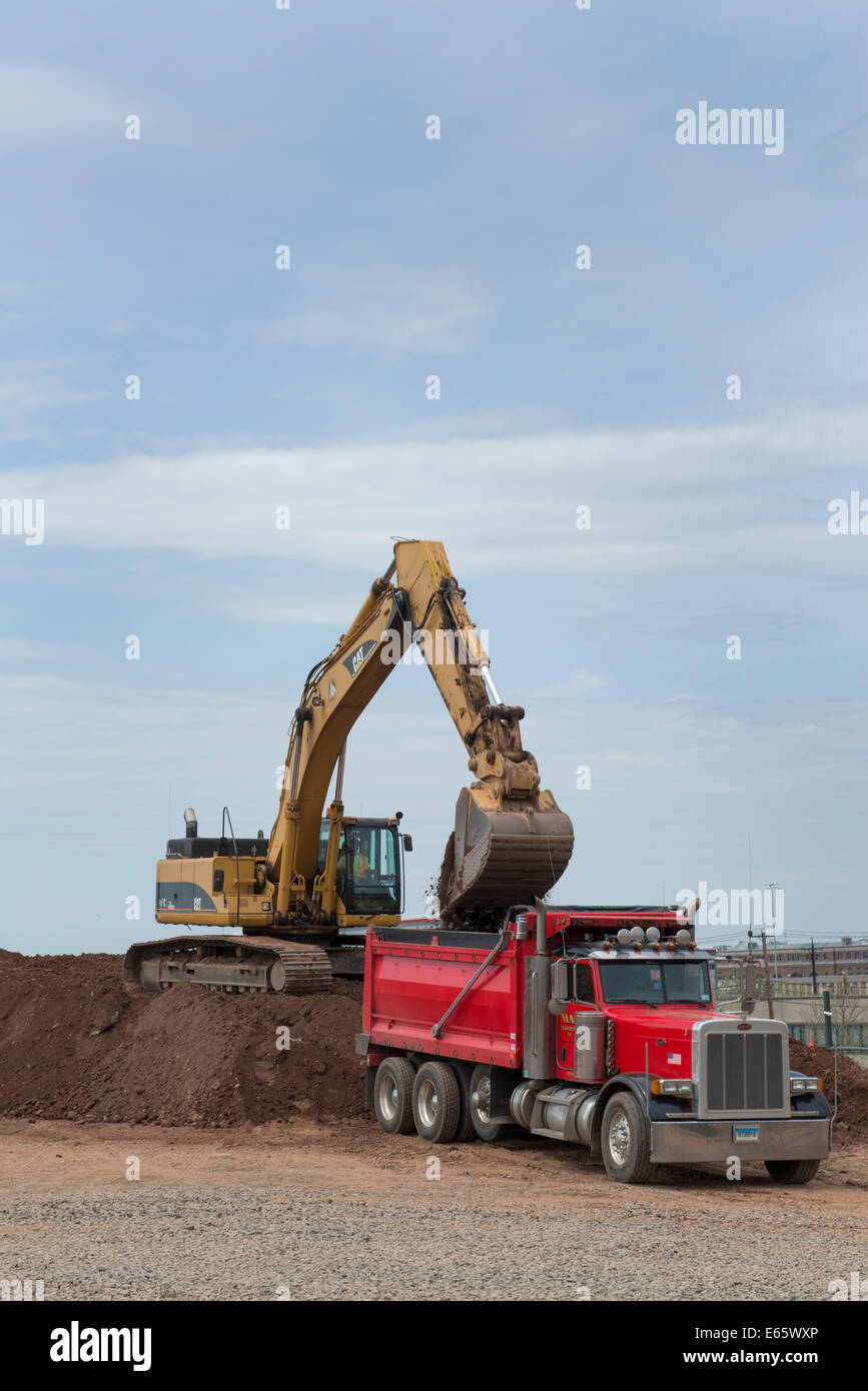 Excavator loads up a dump truck  on re-use pile for I-95 New Haven Harbor Crossing. Stock Photo