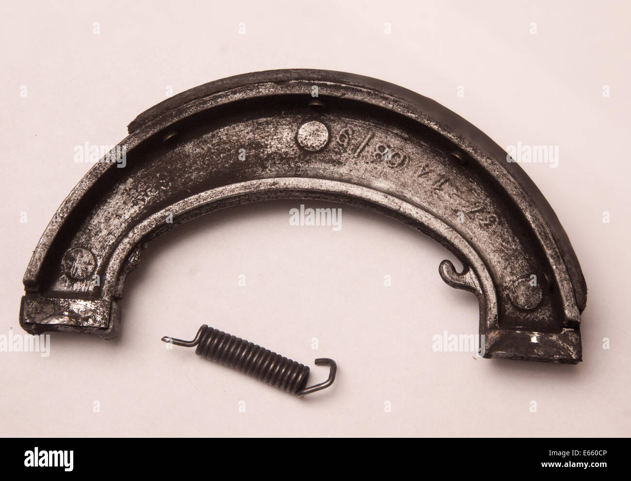 Worn and damaged brake shoe of a Triumph Daytona T100R classic motorcycle, spring and retainer snapped Stock Photo
