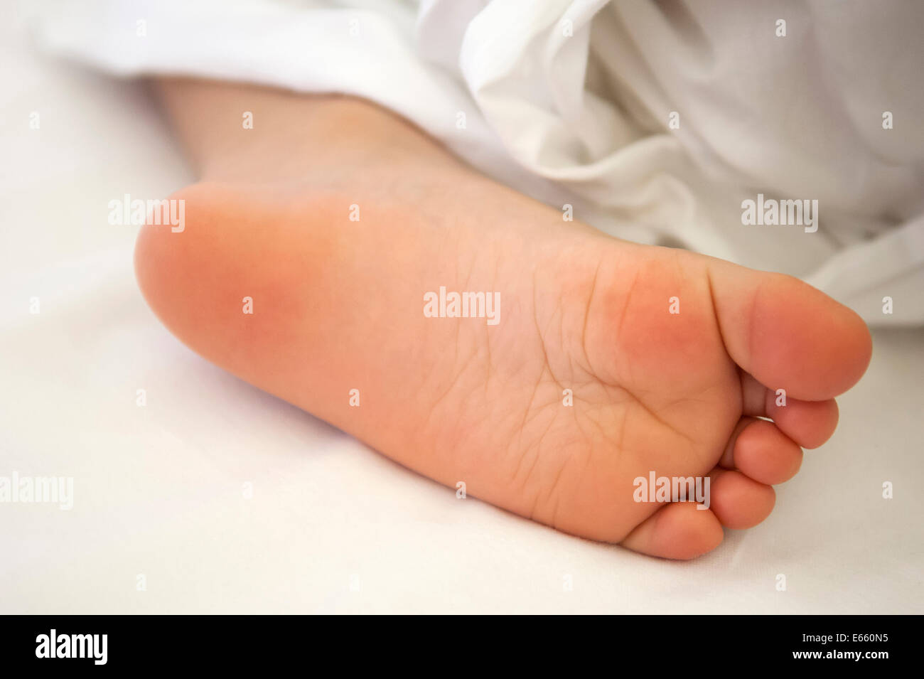 child foot under cover in bed Stock Photo