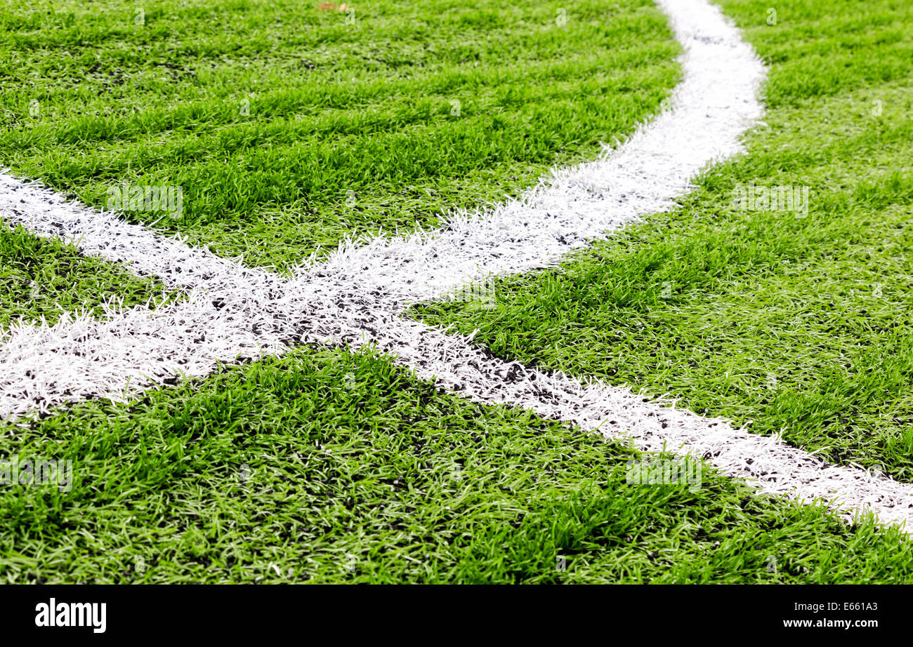 White lines of field markings crossing at a football field made of