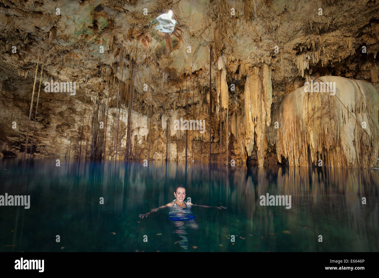 A woman enjoys an early morning swim in the  cenote near Valladolid, Yucatan, Mexico. Stock Photo