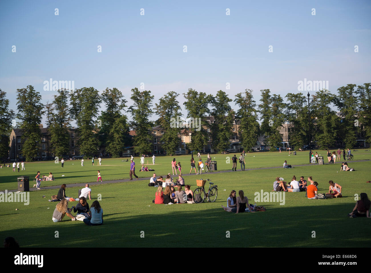 People sitting on the lawn of Parker's Piece common, Cambridge, England, UK Stock Photo