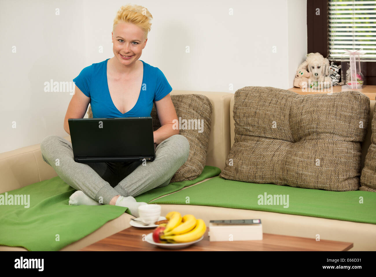 Young woman  with laptop on the couch in living room Stock Photo