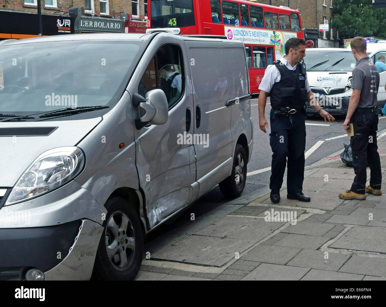 Police officer and driver at scene of road traffic accident in London Stock Photo