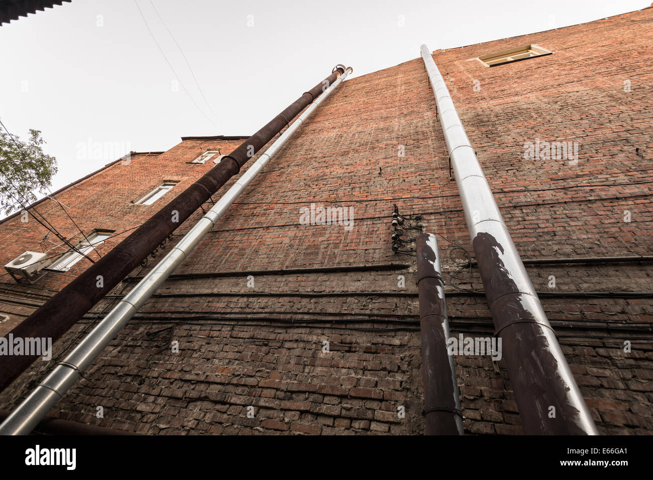 Series of pipes on a brick brown wall ukraine Stock Photo