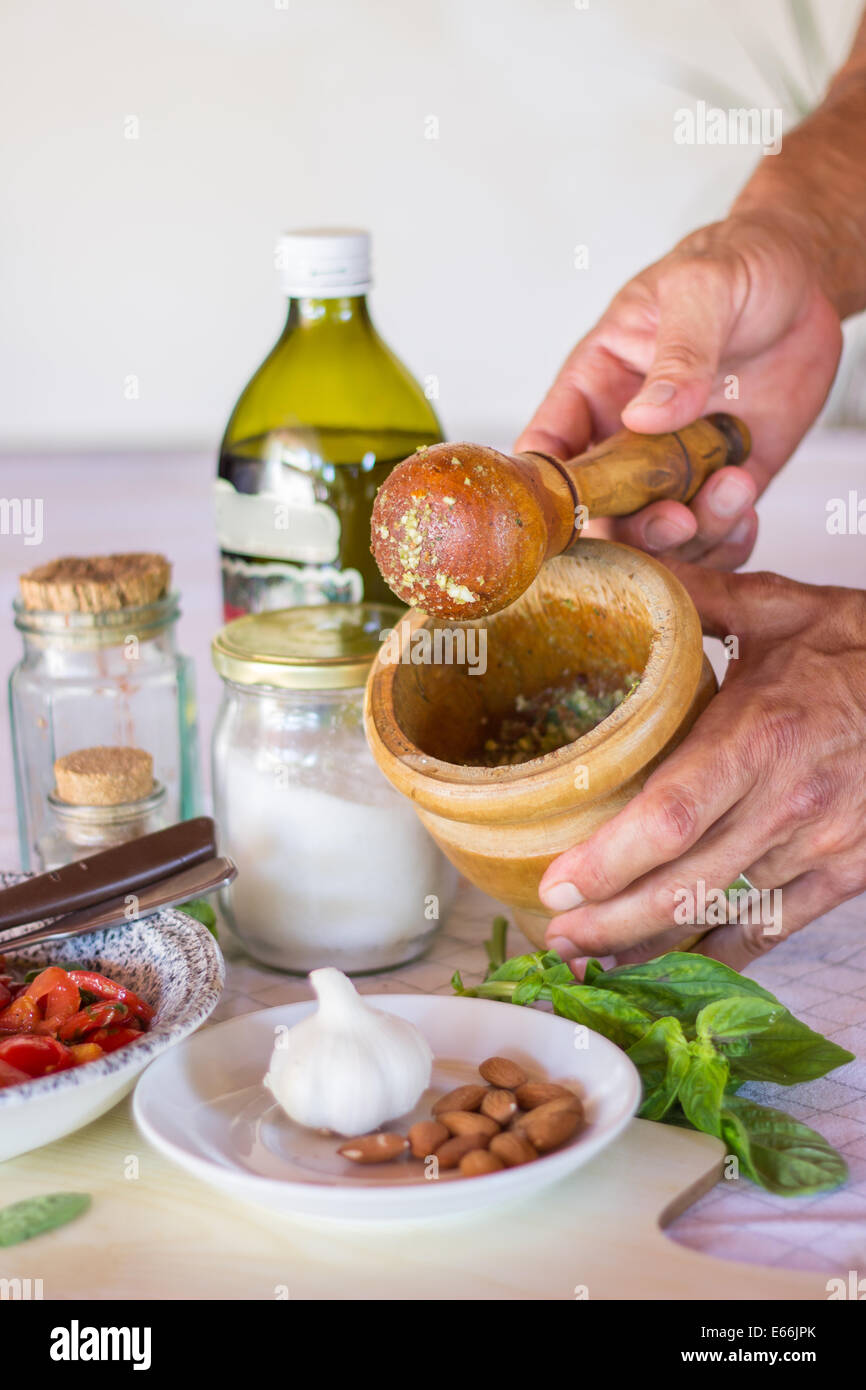 ingredients kitchen 'kitchen counter' hands preparing cooking 'mortar and pestle' ground spices vertical  'olive oil' tomatoes Stock Photo