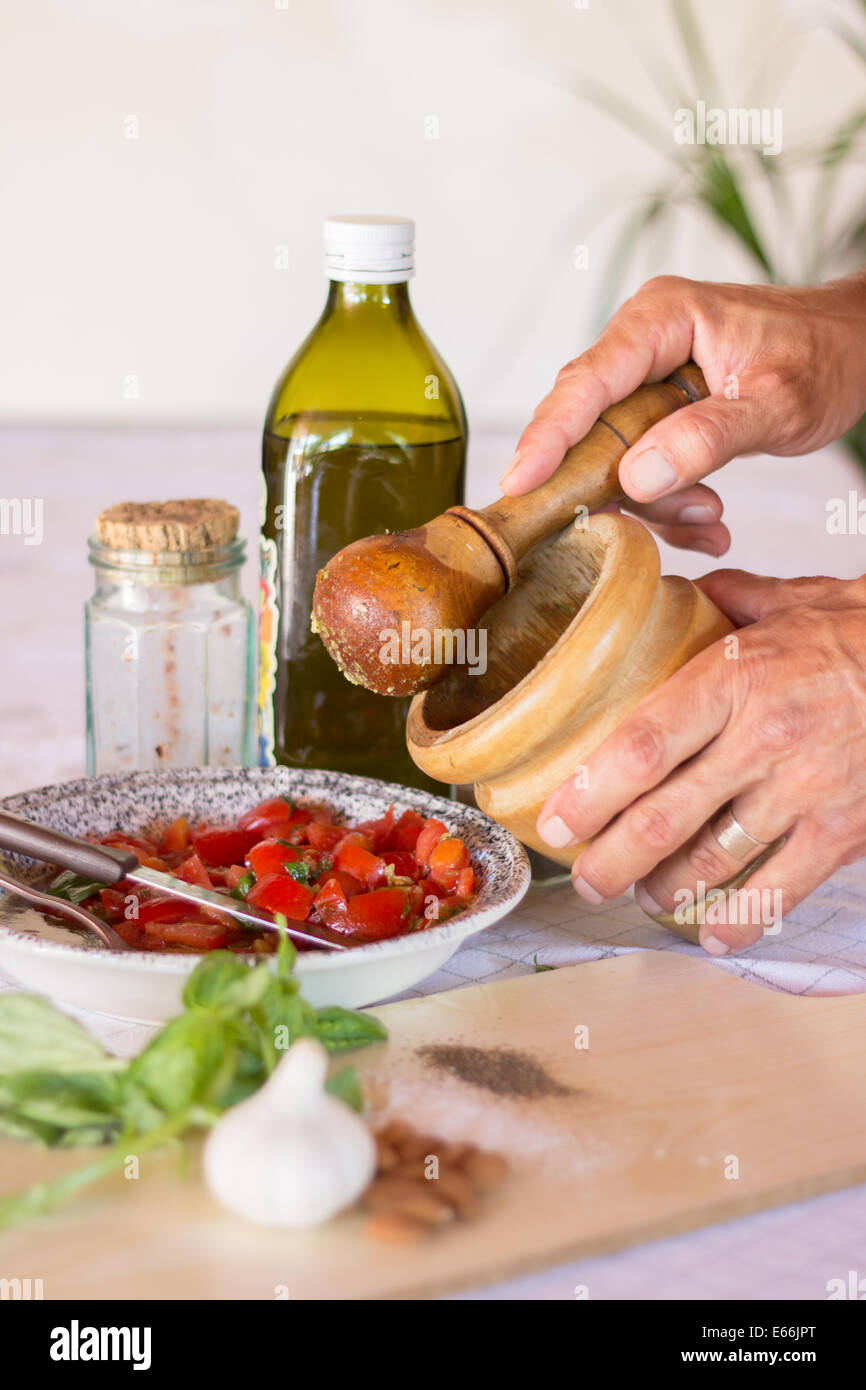 ingredients kitchen 'kitchen counter' hands preparing cooking 'mortar and pestle' ground spices vertical  'olive oil' tomatoes Stock Photo