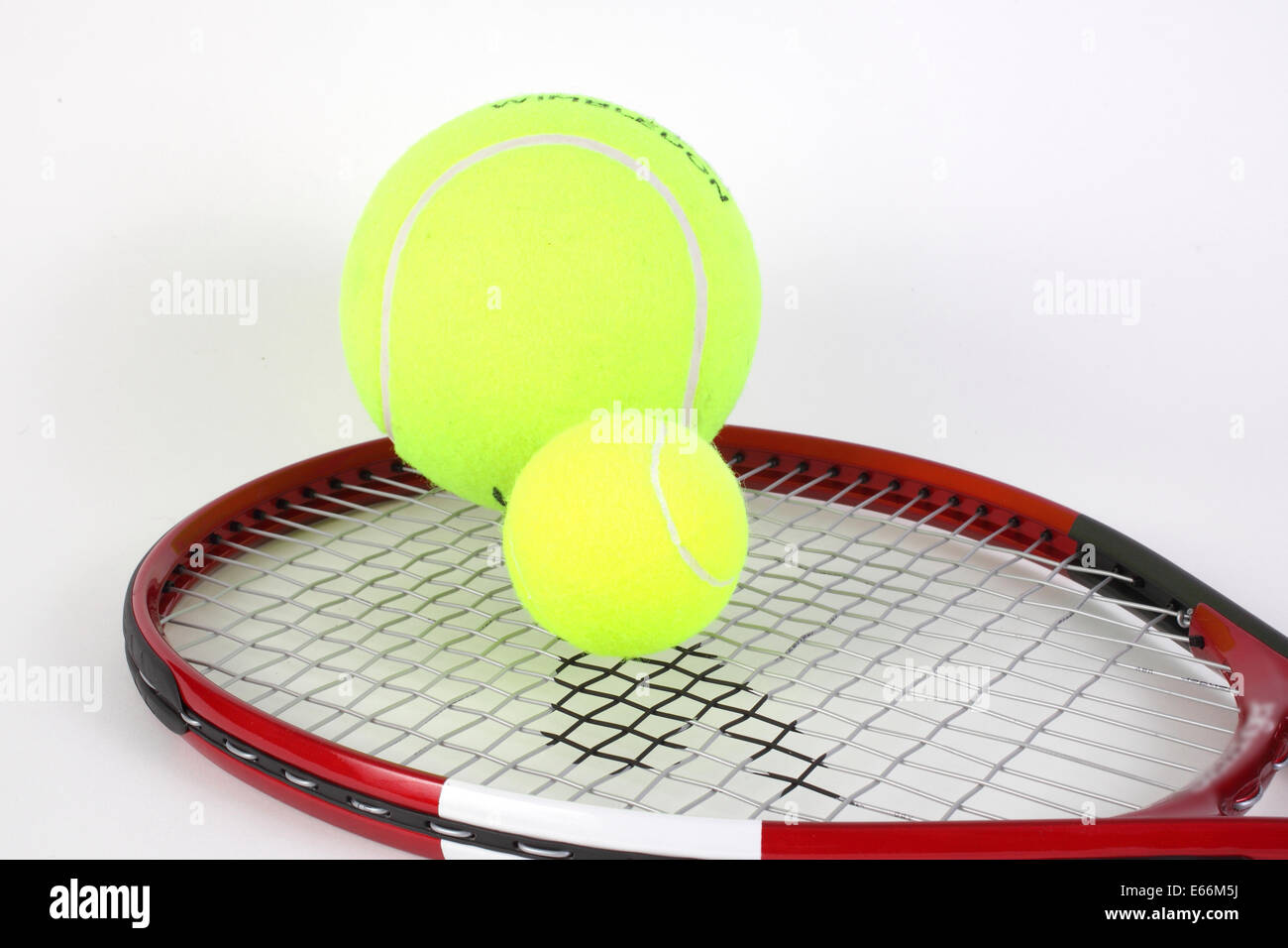 Different size tennis balls on a racket Stock Photo Alamy
