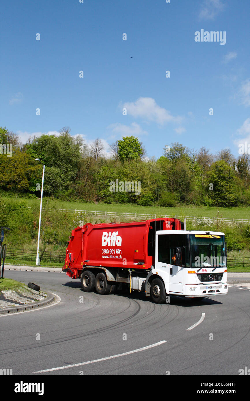 A refuse truck traveling around a roundabout in Coulsdon, Surrey, England Stock Photo