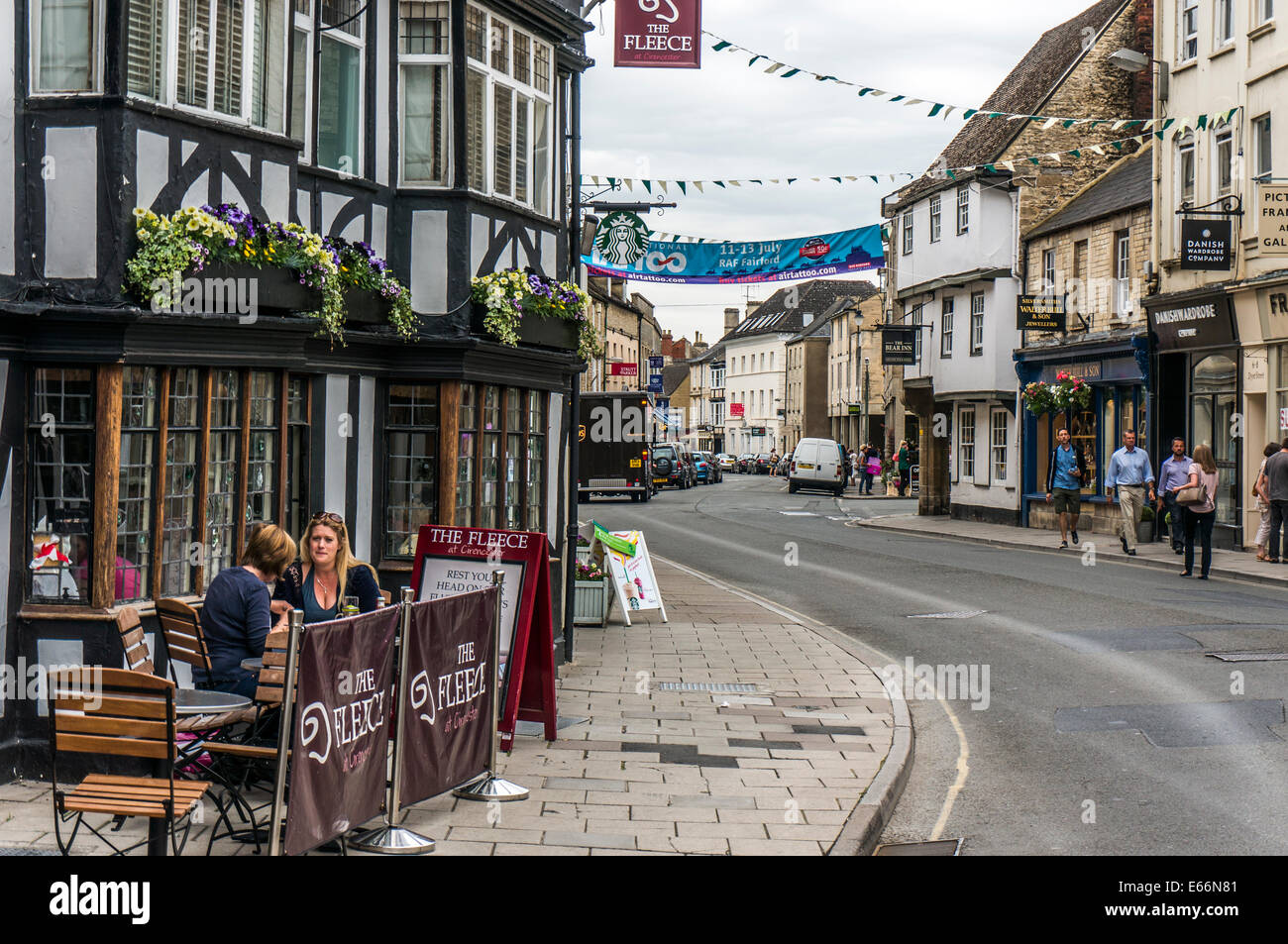 Town centre view with two ladies having a meal outside a restaurant, Cirencester, Cotswolds, Gloucestershire, England, UK. Stock Photo