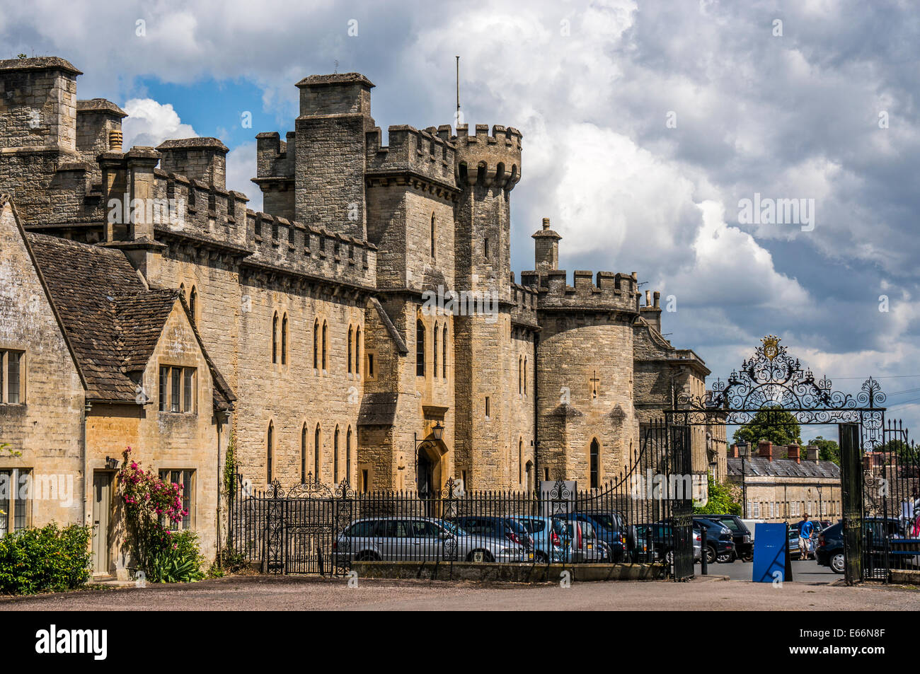 A historic old house next to Cecily Hill barracks (faux medieval castle) at Cirencester Park entrance, Cotswolds, Gloucestershire, England, UK. Stock Photo