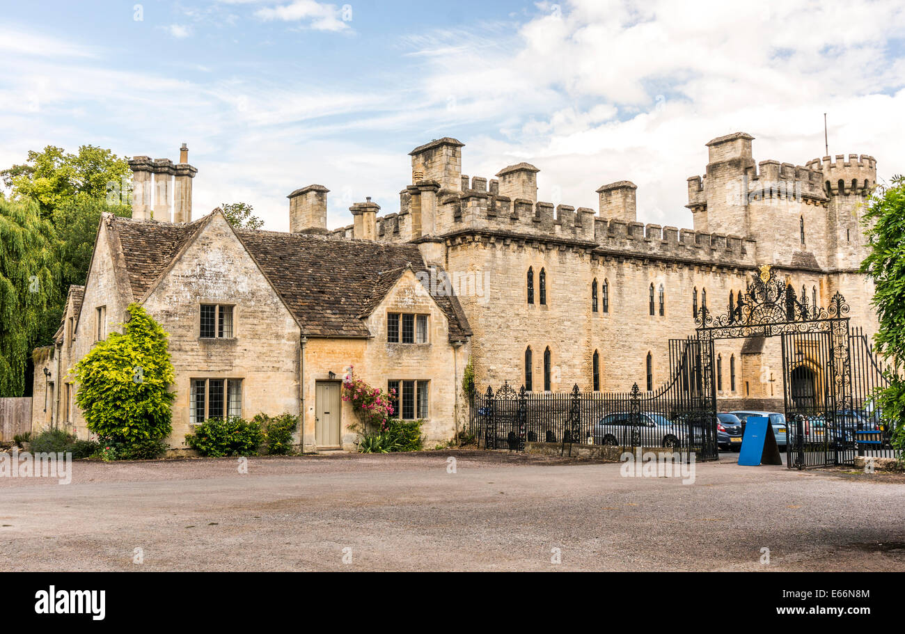 A historic old house next to Cecily Hill barracks (faux medieval castle) at Cirencester Park entrance, Cotswolds, Gloucestershire, England, UK. Stock Photo