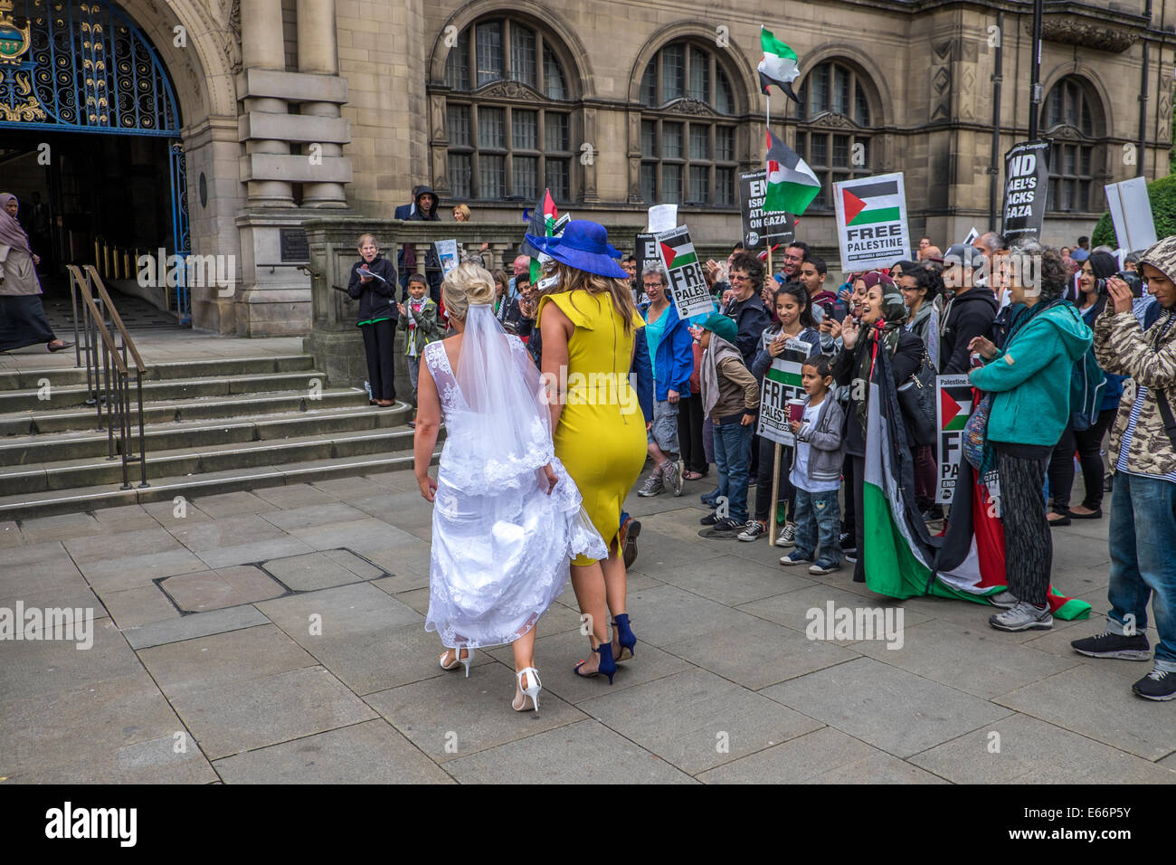 Sheffield, Yorkshire, UK.16th August 2014.Palestine solidarity campaign held a rally outside Sheffield town hall with guest speakers.They late marched to Sainsbury's supermarket in the city centre where they held a silent protest, laying on a Palestinian flag to symbolize the dead kill by the Israeli government.Protesters stand to one side to let the bride into the town hall building.The crowd clap and cheer her along on her wedding day. Credit:  Ian Francis/Alamy Live News Stock Photo