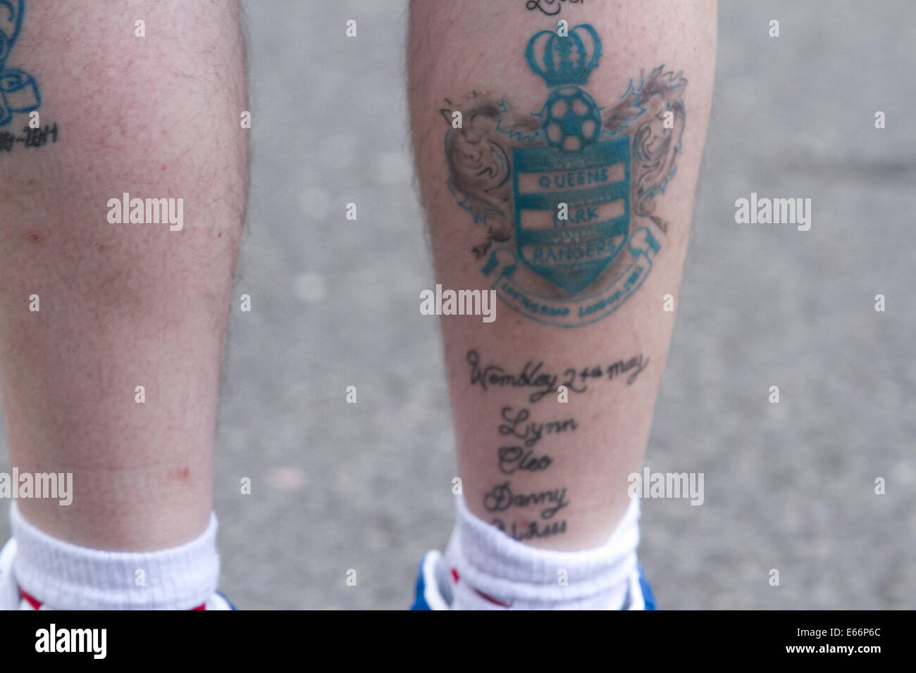 London,UK. 16th August 2014. A supporter with a QPR club crest tattooed on his leg. Football supporters arrive on the opening day of the English football league season fixture between Queens Park Rangers FC and Hull FC at Loftus Road London Credit:  amer ghazzal/Alamy Live News Stock Photo