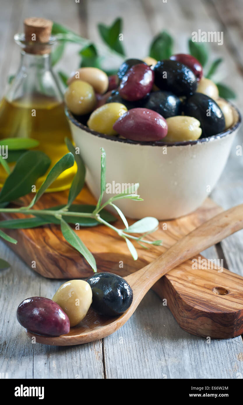 Mixed marinated olives (green, black and purple) in ceramic bowl and