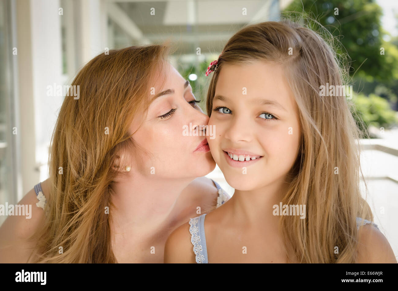 Mother kissing her daughter in the cheek. Taken in Buenos Aires, Argentina. Stock Photo