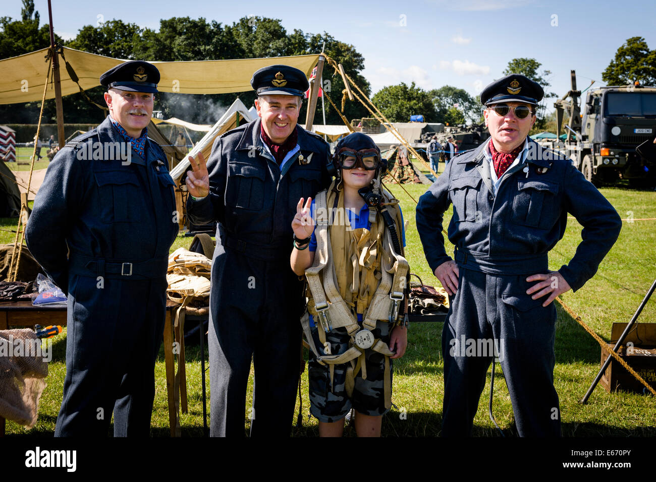 Kent, UK. 16th Aug, 2014. Men in RAF uniforms posing for photos to collect for charity at The 6th Annual Combined Ops Show at Headcorn Airfield. Featuring fly-overs, war re-enactments, fancy dress, actual and replica memorabilia, and more. Credit:  Tom Arne Hanslien/Alamy Live News Stock Photo