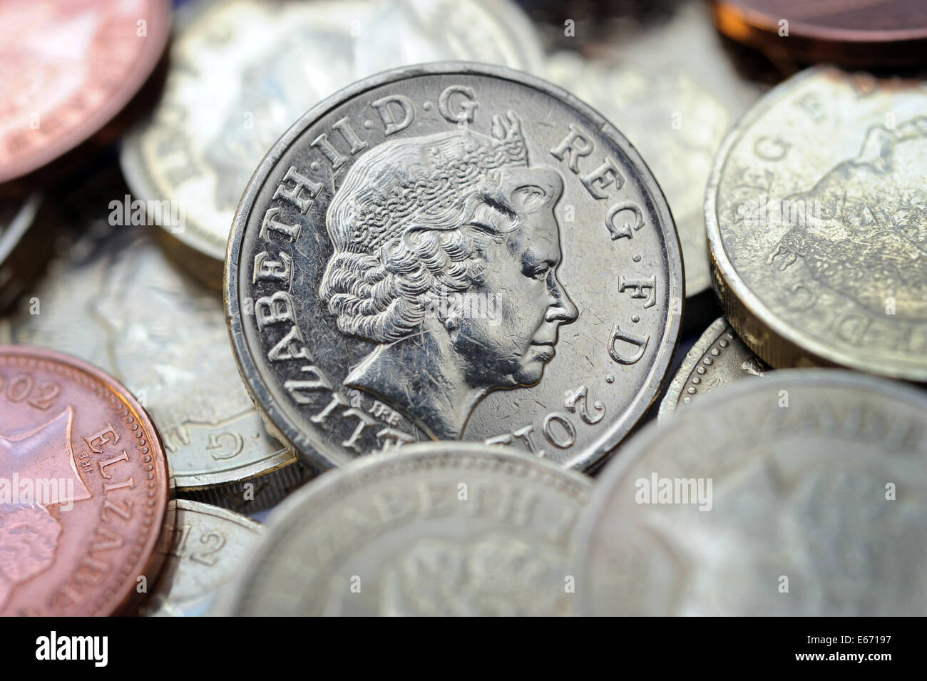 BRITISH ONE POUND COIN AMONGST OTHER COINS RE THE ECONOMY WAGES INCOMES SAVINGS MORTGAGES INTEREST RATES HOME BUYERS SAVERS UK Stock Photo