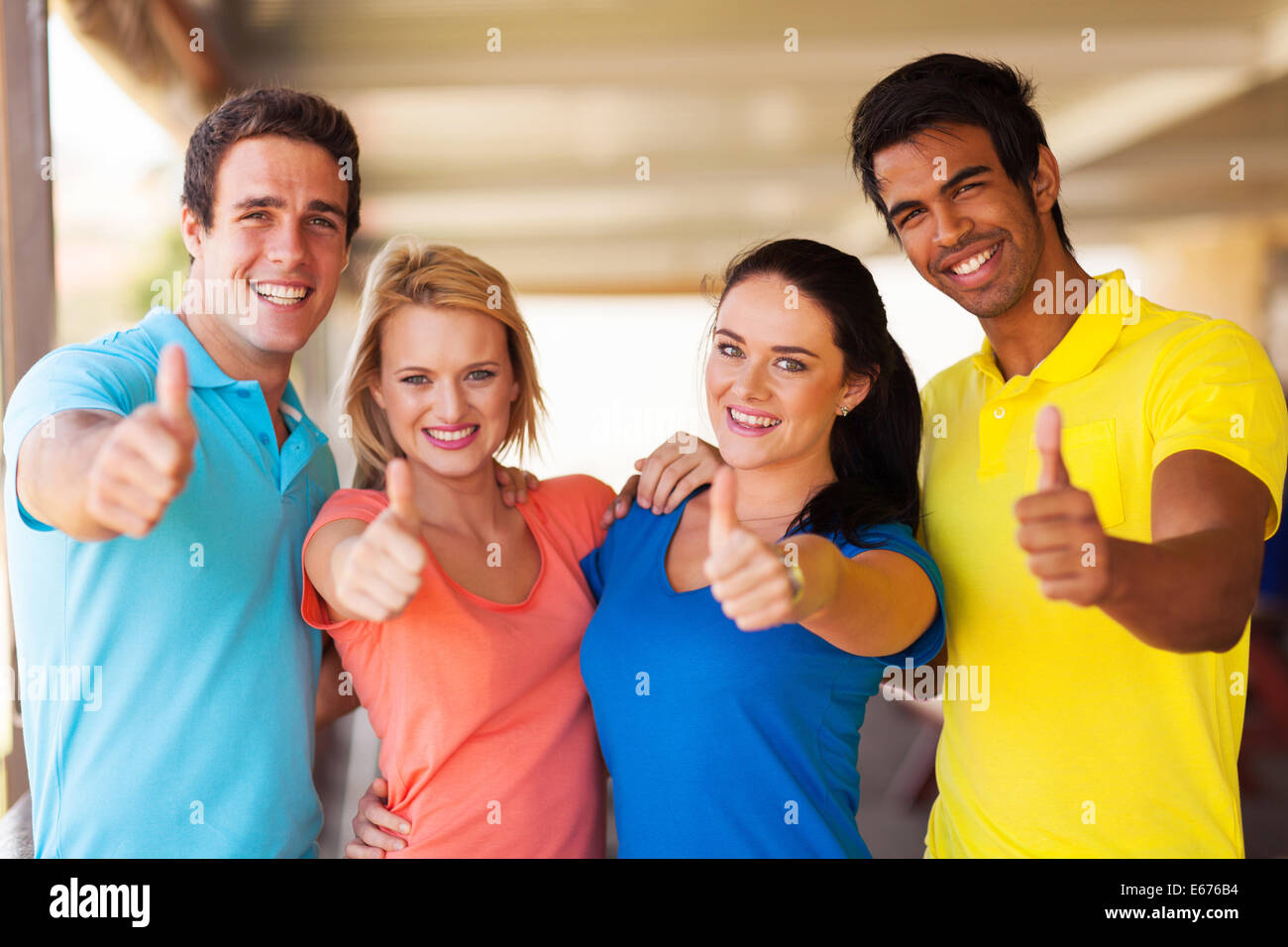 group of cheerful friends giving thumbs up Stock Photo
