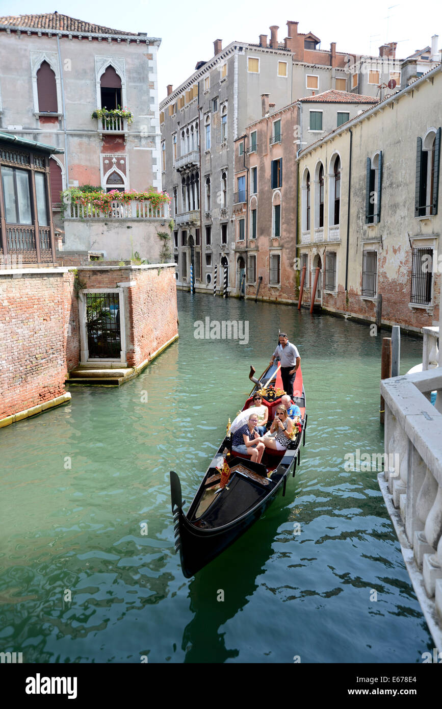 Italy Venice San Polo Gondolier with tourists on a quite side canal of Venice Stock Photo