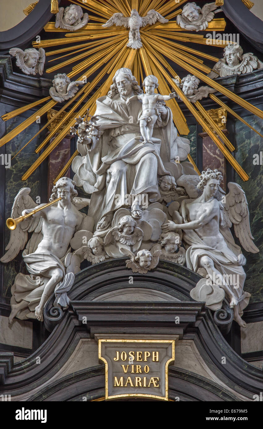 BRUGES, BELGIUM - JUNE 13, 2014: The carved statue of st. Joseph with the child and angesl on the main altar in Karmelietenkerk Stock Photo