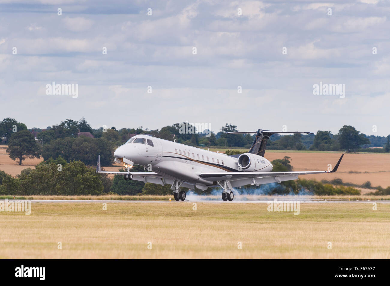 A plane Embraer ERJ-135/145 (G-WIRG) landing at Luton Airport in England , Britain , Uk Stock Photo