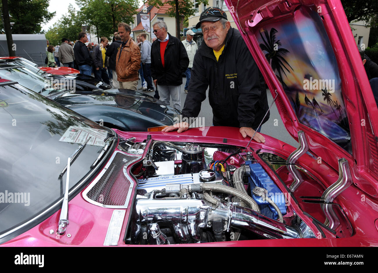 Rastede, Germany. 17th Aug, 2014. Otto Muschalik from Hude presents the chromed 2.4 liters four-cylinder engine of his pimped Opel GT from 1971 at the 8th vintage car meeting for cars and motorcycles in Rastede, Germany, 17 August 2014. Photo: Ingo Wagner/dpa/Alamy Live News Stock Photo