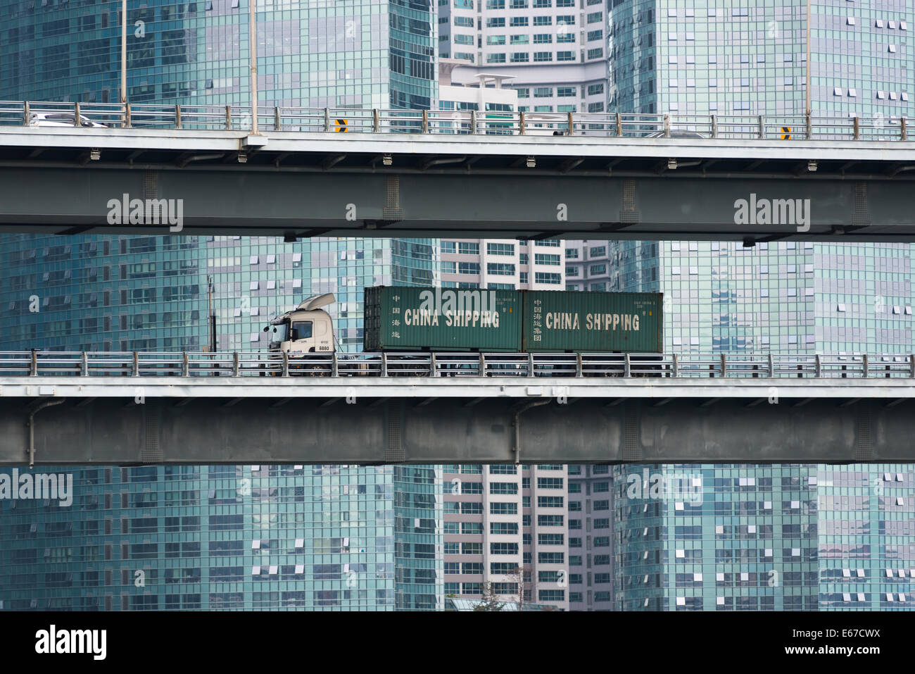 A Chinese lorry goes past the modern glass skyscrapers of Centum City, Pusan, South Korea. Stock Photo