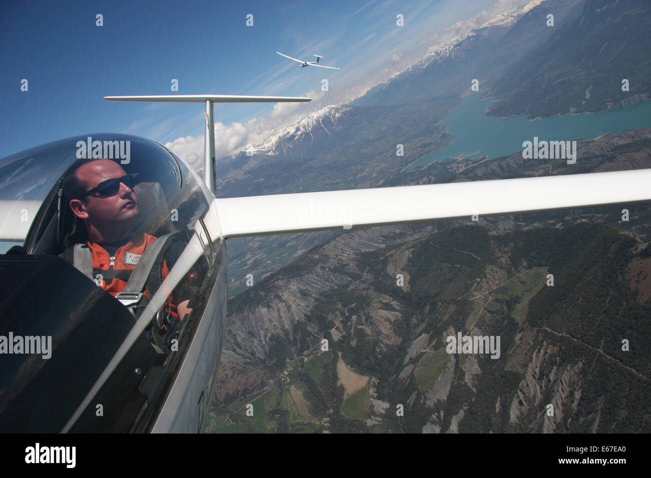 Pilot flying sailplane over an Alpine lake takes adventure selfie Stock Photo